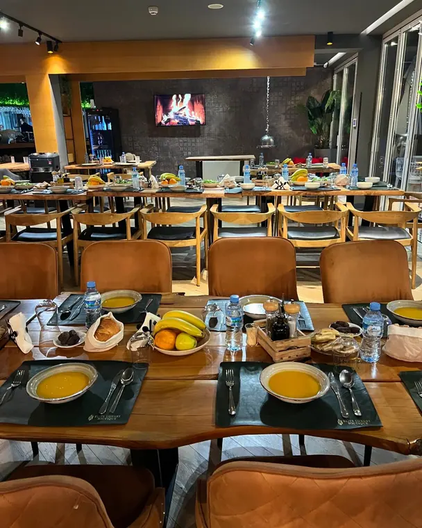 Dining room with set tables and wall screen showing a fire