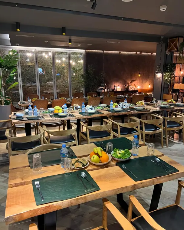 Dining room with several long tables set for a group meal