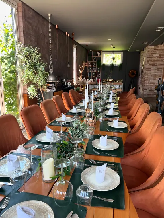 Long banquet table set with green placemats and candles