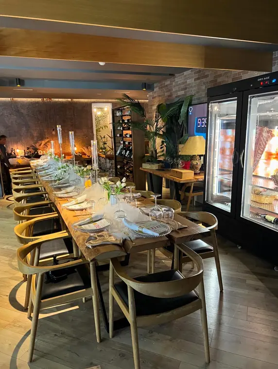 Long set table beside dry-aging meat display cabinet