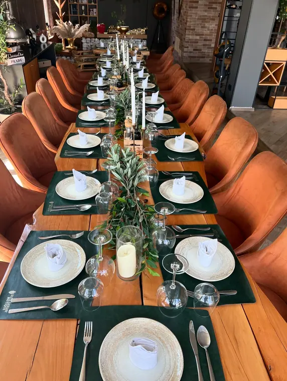 Overhead view of long banquet table with olive branch runner