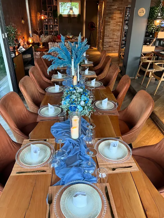 Overhead view of long table set with blue runner and pampas