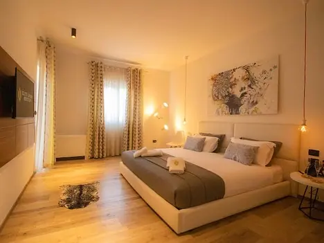 Bedroom with painting above bed and patterned curtains