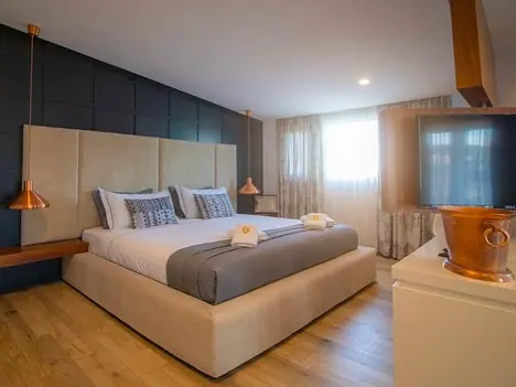 Double room with padded headboard, copper pendant lamps and TV