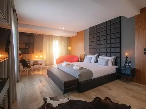 Suite with padded headboard, red chair and desk by window